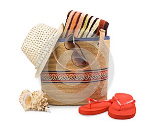 Beach bag and towel with sunbathing accessories isolated on white