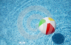 Beach ball floating in swimming pool