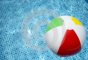 Beach ball floating in swimming pool abstract