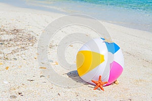 Beach ball and star fish on the sand