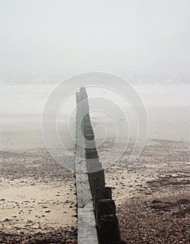 Beach barrier on a misty day abstract