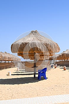 Beach with beach umbrella made of straw.