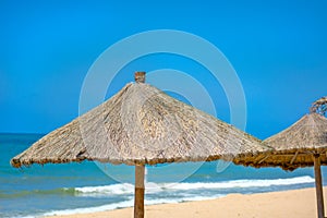 Beach beautiful thatched umbrellas and bright turquoise sea, great recreation and relaxation. tropical paradise.