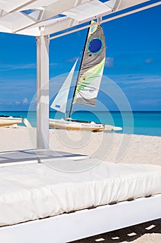 Beach beds and a sailboat on the beach of Varadero in Cuba