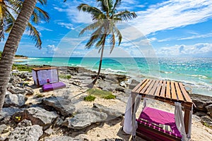 Beach beds under the palm trees on paradise beach at tropical Resort. Riviera Maya - Caribbean coast at Tulum in Quintana Roo,