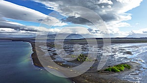 Beach with black volcanic sand in Iceland, Epic aerial view, Green grass grow in black sand, Unearthly landscape, Ocean