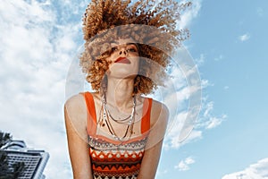 Beach Bliss: Smiling woman with a backpack enjoying a carefree dance on the sand, embracing the hippie spirit of freedom