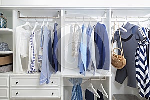 Beach blue clothes hanging in white wardrobe in home