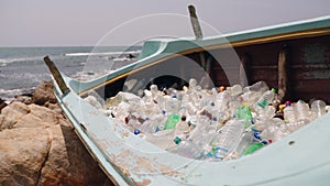 Beach boat with plastic bottles, marine pollution crisis. Litter, trash, garbage dump of human plastic waste management