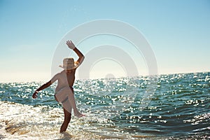 Beach boy dancing having fun backlight littered horizon