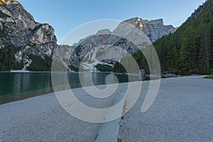 Beach a of the Braies lake towards sunset with Croda del Becco Peak background