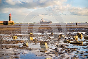 Beach in Bremerhaven at low tide with shipping on the Weser in the background