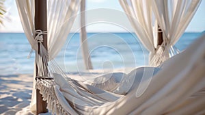 A beach cabana with a comfortable hammock and soft white curtains swaying in the breeze providing the perfect setting