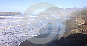 The beach is calm and peaceful with a few rocks scattered around