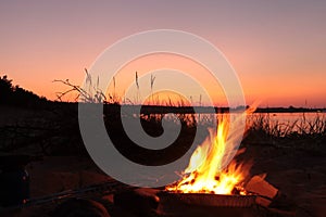 Beach Campfire on Lake. Red sky Superior at sunset as vacation concept