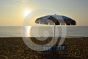 Beach canvas beds with blue and white umbrella