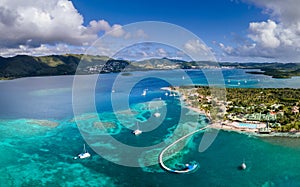 Beach in Caribbean island bay in Antilles with transparent turquoise sea water and coral reefs, aerial drone panorama, white sand