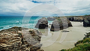 Beach of the Cathedrals full of rocks with crystal clear water in the background, Spain