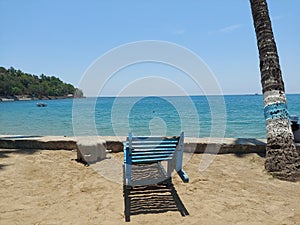 A beach chair  at corbyns cobe  beach  with coconut  trees  and blue water