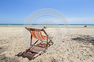 Beach chairs on the and beach with cloudy blue sky.