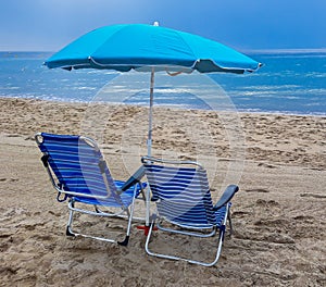 Beach chairs with blue umbrella and beautiful beach on a sunny day. Benidorm, Spain