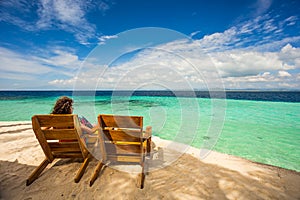 Beach chairs, clear water and beautiful view on tropical island,