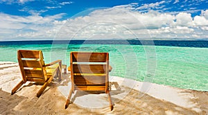 Beach chairs, clear water and beautiful view on tropical island, near Palawan, Phillippines