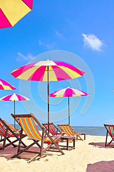 Beach chairs and colorful umbrella on the beach with blue sky, Cha am, Thailand