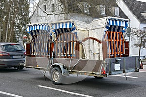 Beach chairs or German Strandkorb on a car trailer are driven to the coast for vacation at the sea when the season starts,
