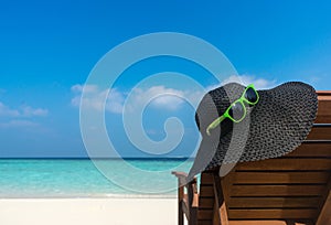 Beach chairs with hat on white sandy beach