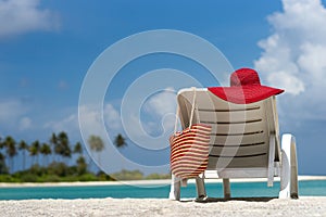 Beach chairs with hat on white sandy beach