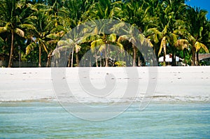 Beach chairs, palm trees and beautiful white sand beach in tropical island