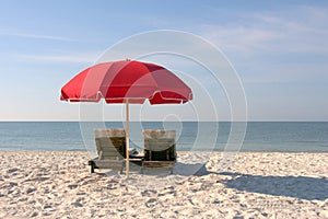 Beach Chairs with Red Umbrella on White Sandy Beach