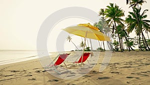 Beach chairs and sun umbrella on the beach. Sunset on the island beach