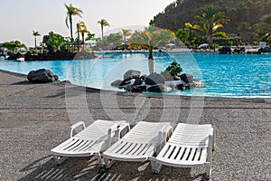 Beach chairs in swimming pool at resort