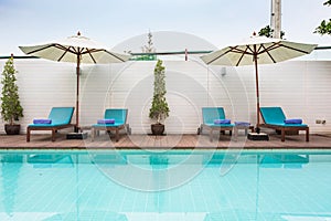 Beach chairs and swimming pool in the resort holiday.