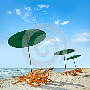 Beach chairs and umbrella on beach.
