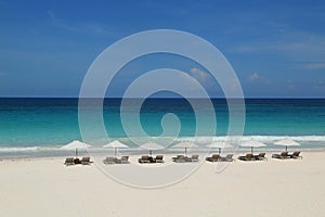 Beach chairs and umbrella on a beautiful Caribbean beach at Harbor Island