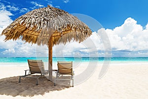 Beach chairs with umbrella and beautiful sand beach in Punta Can