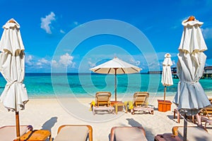 Beach chairs with umbrella at Maldives island with white sandy b