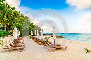 Beach chairs with umbrella at Maldives island, white sandy beach
