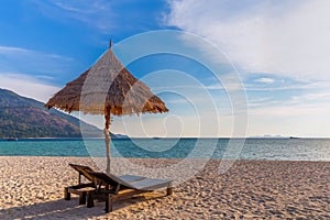 Beach chairs, umbrella and palms on the beautiful beach for holidays and relaxation at Koh Lipe island, Thailand