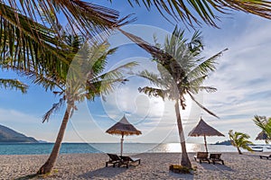 Beach chairs, umbrella and palms on the beautiful beach for holidays and relaxation at Koh Lipe island, Thailand