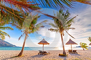 Beach chairs, umbrella and palms on the beautiful beach for holidays and relaxation at Koh Lipe island, Thailand