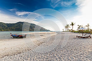 Beach chairs, umbrella and palms on the beautiful beach for holidays and relaxation at Koh Lipe island, Thailand