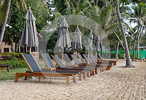 beach chairs and umbrella on sand beach with tropical vacation at sea