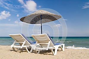 Beach chairs and umbrella on tropical beach