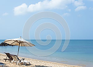 Beach chairs and umbrella on white sand beach