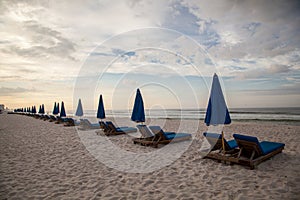 Beach chairs and umbrellas await beach goers on Panama City Beach.