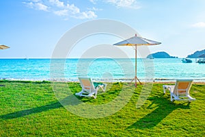 Beach chairs and beach umbrellas are on the lawn at the beach.Sea view and bright sky.